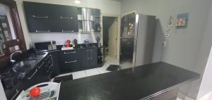 阿雷格里港Casa-Ampla Porto Alegre-RS的厨房配有黑色台面和冰箱