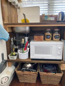 吉斯伯恩Gisborne Dream Suite的带微波炉和餐具篮的厨房架