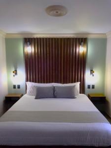 Ciudad HidalgoAñoranza Hotel Boutique的卧室配有一张白色大床和木制床头板