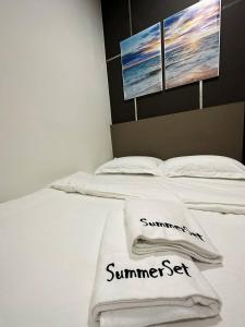 哥打京那巴鲁K Avenue Seaview Nearby Kota Kinabalu Airport的一张白色的床,上面有两条毛巾