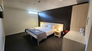 皇后镇Nomads Queenstown Hostel的酒店客房配有一张床铺和一张桌子。