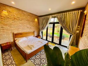 波来古市Paksong Farmstay Gia Lai - Venuestay的一间卧室设有一张床和砖墙
