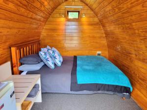 RuahineFlat Hills Tourist Park的小木屋内一间卧室,配有一张床
