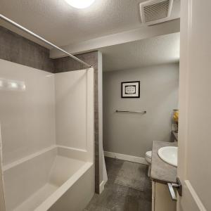 尼斯库Rare find. Legal basement suite with separate ent.的带浴缸和盥洗盆的浴室