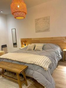 诺诺Magnolia Suites的一间卧室配有一张大床和木制床头板