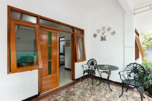 BantarkamangHouse of M Bogor Mitra RedDoorz的配有桌椅和门的房间