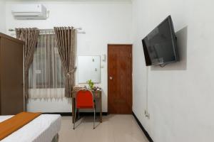 BantarkamangHouse of M Bogor Mitra RedDoorz的一间房间,配有一张床和墙上的电视