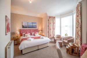 斯特兰拉尔克莱格尼尔德酒店的一间卧室配有一张带粉红色床头板的大床