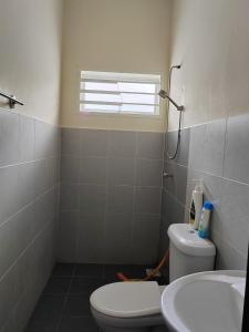 Kampong JemamparTeratak Delisha -musslim的一间带卫生间、水槽和窗户的浴室