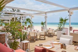 贝尔马尔LUX* Belle Mare Resort & Villas的海滩上带桌椅的餐厅