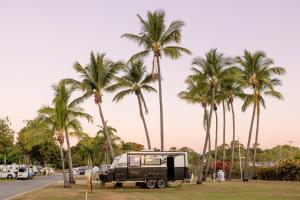 汤斯维尔BIG4 Townsville Gateway Holiday Park的停在棕榈树公园里的卡车
