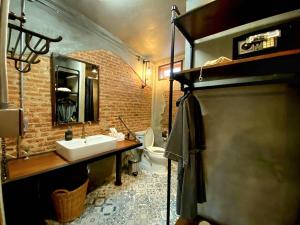 曼谷House of Machine Boutique Hotel的一间带水槽和砖墙的浴室
