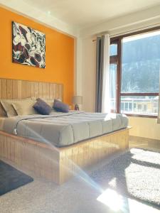 卡索尔Himtrek Stays, Kasol的一间卧室配有一张带橙色墙壁的大床