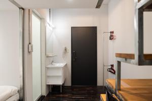 台北米尼旅店的浴室设有黑色的门和水槽。