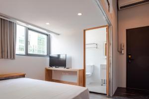 台北米尼旅店的一间卧室配有一张床、一台电视和一间浴室。