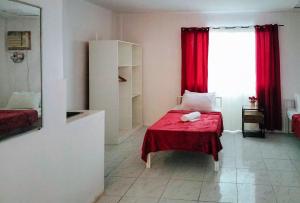 巴科洛德RedDoorz at Rio Bella Lacson St Bacolod的一间卧室配有一张带红色毯子的床和窗户。