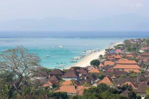 蓝梦岛Castaway Island Hostel的享有海滩美景,设有房屋和大海