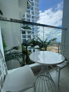 绥和市Apec Mandala Phú Yên的阳台上配有白色的桌椅