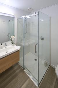 基督城Central City Apartments的一间带玻璃淋浴和水槽的浴室