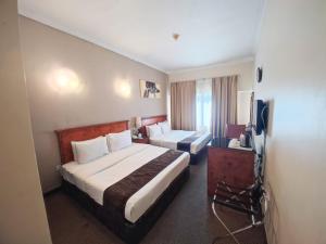 沙迦那约姆阿尔埃玛拉特酒店的酒店客房设有两张床和电视。