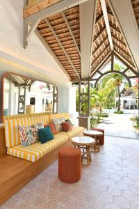 贝尔马尔Veranda Palmar Beach Hotel & Spa - All Inclusive的客厅设有沙发,位于庭院