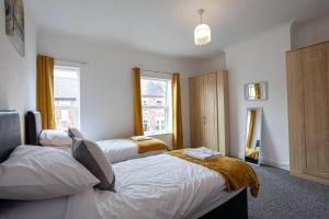 特伦特河畔斯托克Inspired Stays- City Centre- Spacious 4 Bed House!的一间卧室设有两张床和窗户。