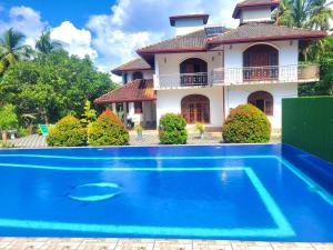 阿鲁特伽马Charly Villa的房屋前有游泳池的房子