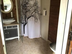 DuķuriTreehouse Čiekurs的浴室墙上有一棵树。