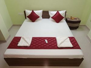 钦奈Ananya service apartments的一张带红色枕头的大床