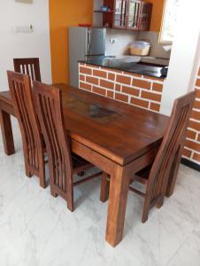加姆珀哈Anne's Homestay的厨房里配有一张木桌和椅子