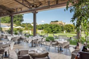 格里尼昂La Ferme Chapouton - Teritoria的庭院内的餐厅,配有桌椅