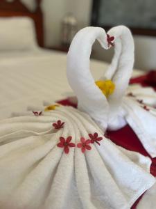 琅勃拉邦Villa Namkhan Heritage的床上的白色毛巾,带鲜花