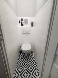 希维博津Apartament Widok的一间带卫生间的浴室以及黑色和白色的瓷砖地板。