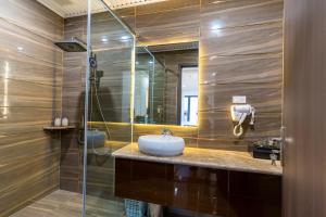 海防CM Hotel & Apartment的一间带水槽和玻璃淋浴的浴室