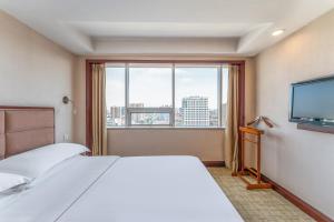保定保定中银大厦的酒店客房设有一张床和一个大窗户