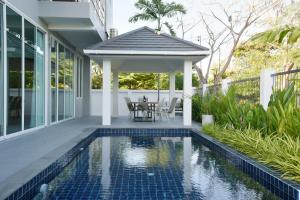 Bang KrasopGreen Lung Pool Villas Bangkok的一座带游泳池和凉亭的房子