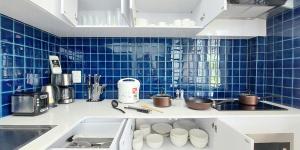 Bang KrasopGreen Lung Pool Villas Bangkok的厨房配有水槽和蓝色的瓷砖墙壁