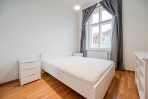 布拉格皮斯托苏U3酒店的白色的卧室设有床和窗户