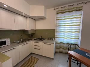贝加莫Comfort Accommodation Residence的一间小厨房,配有白色的橱柜和窗户