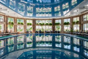 Alamedin詹纳特度假酒店的一座带窗户的建筑中的室内游泳池