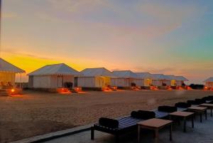 山姆Desert Safari Camp & Resort Sam的日落时在海滩上搭起一组帐篷