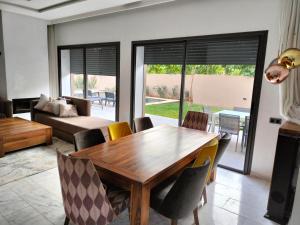 马拉喀什Marrakech Villa du Golfeur familles uniquement的客厅配有木桌和椅子