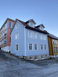 特罗姆瑟Enter Tromsø - Luxury 4 Bedroom Apartment的靠近一些建筑的蓝色和白色建筑