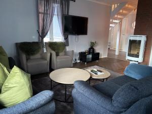 特罗姆瑟Enter Tromsø - Luxury 4 Bedroom Apartment的带沙发、桌子和电视的客厅