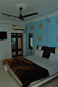 珀勒德布尔Hotel Pratap Palace的卧室设有一张大床,拥有蓝色的墙壁