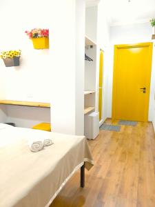 第比利斯Hotel NBL Color in的一间设有床和黄色门的房间