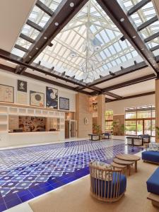 萨洛H10萨拉乌里斯皇宫酒店的大型客房设有玻璃天花板和瓷砖地板。