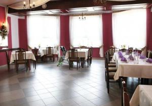 ŁęcznaPensjonat Emocja的一间设有桌椅和红色墙壁的餐厅