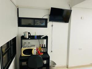 科尔多瓦bedroom and private bathroom Habitacion y baño privado - en una casa的一间配有微波炉和电视的小房间
