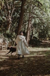 阿尔努埃罗VIBE LUXURY CABINS的穿着衣服的女人在公园里走狗